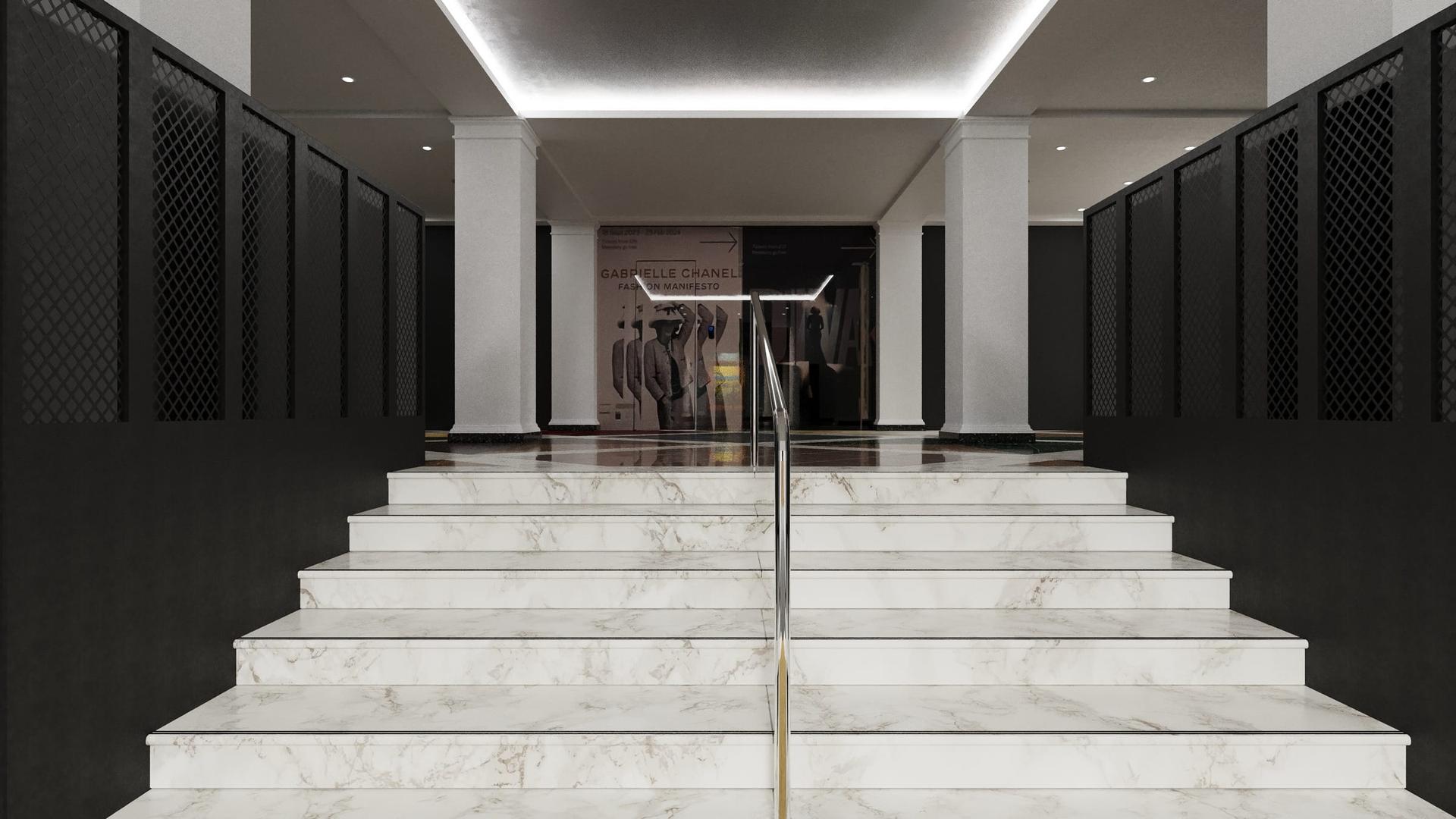 White marble stair with a brass inlay strip, flanked by perforated black screens, in a retail fit-out