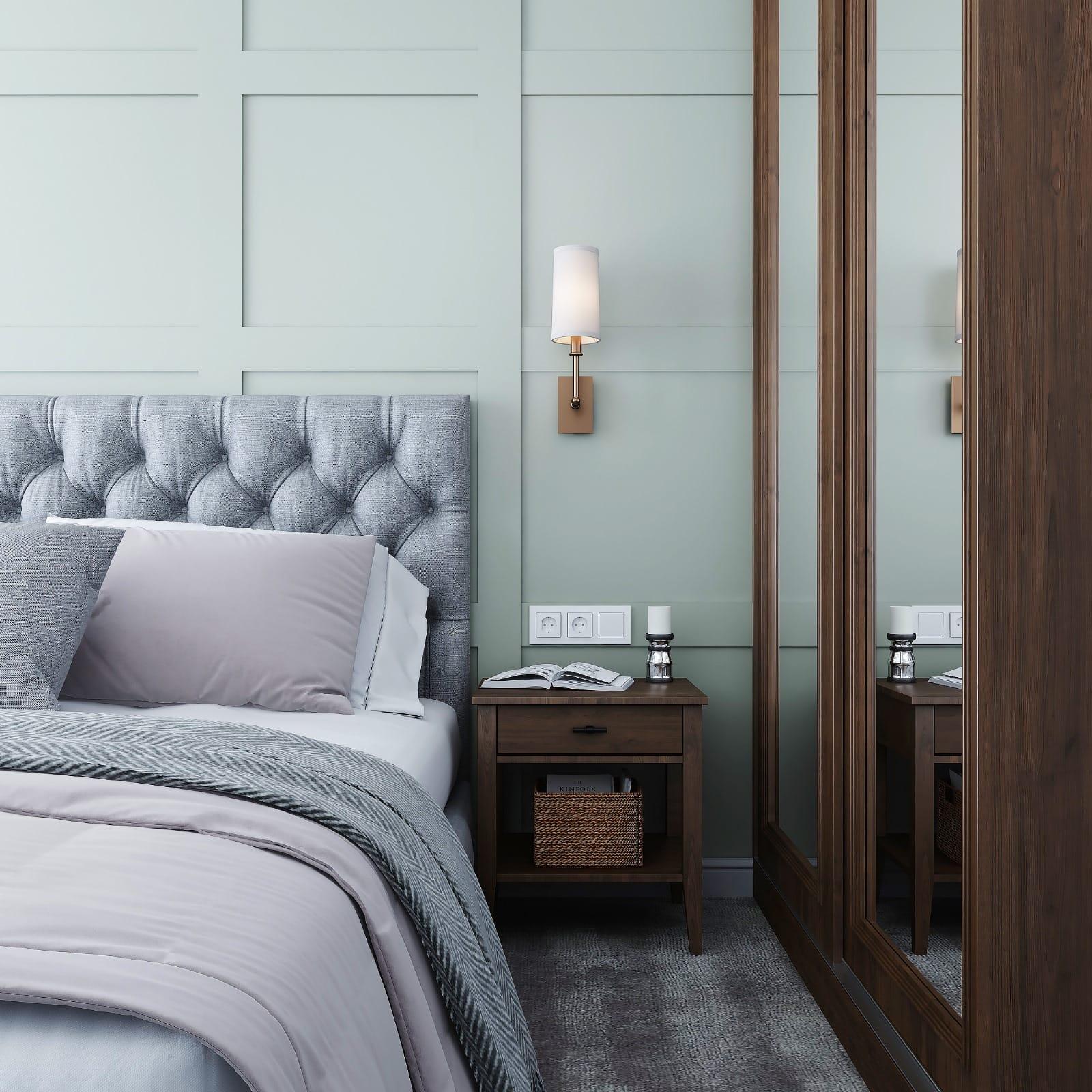 Bedroom in sage panelled joinery with a buttoned headboard and a walnut-framed mirrored wardrobe