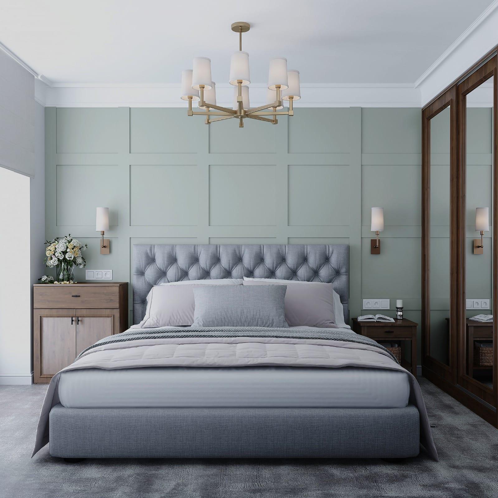 Panelled sage bedroom wall behind a buttoned bed, with wall lights and a walnut mirrored wardrobe run