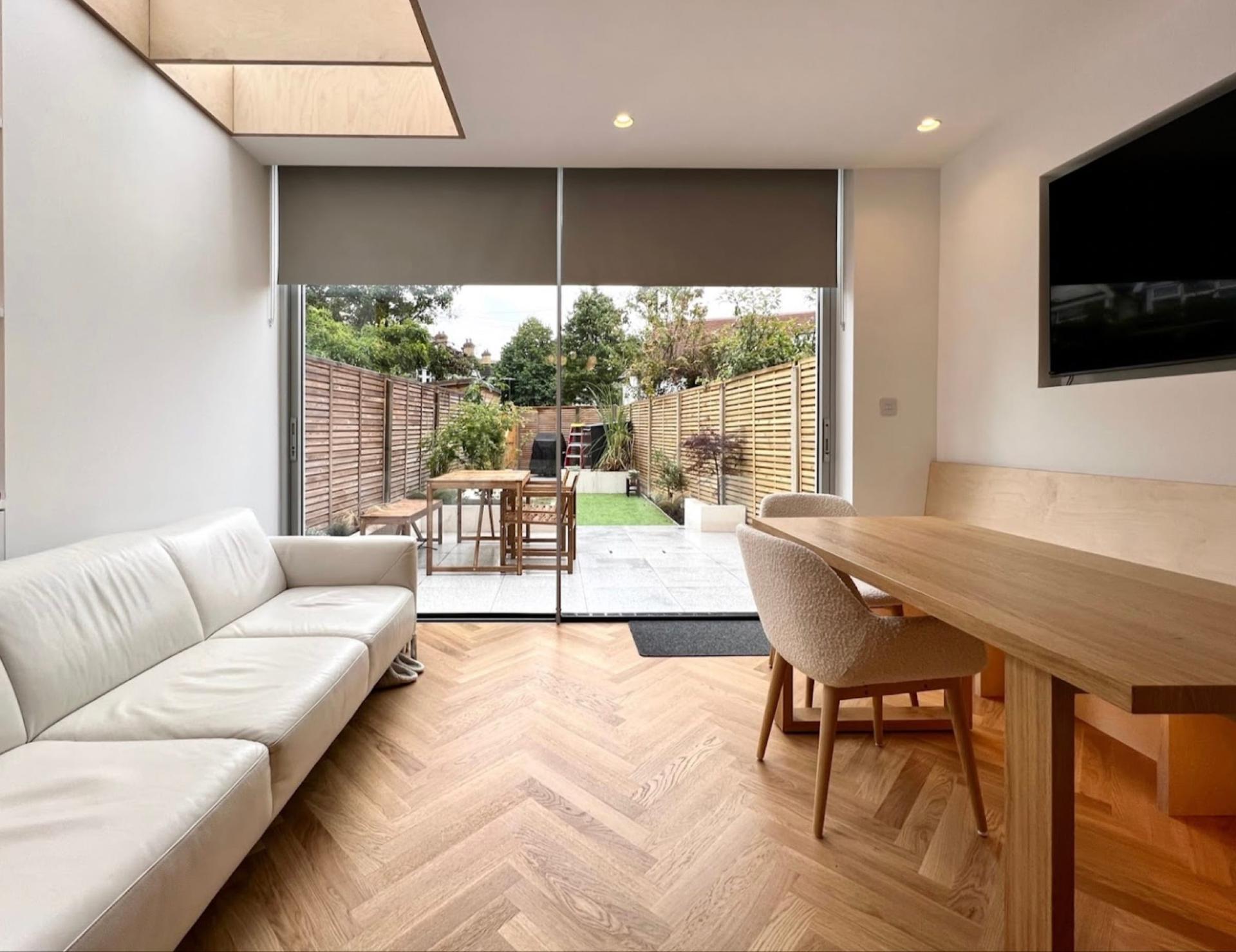 Living and dining space in a rear extension, sliding doors to the patio and a plywood-lined ceiling reveal