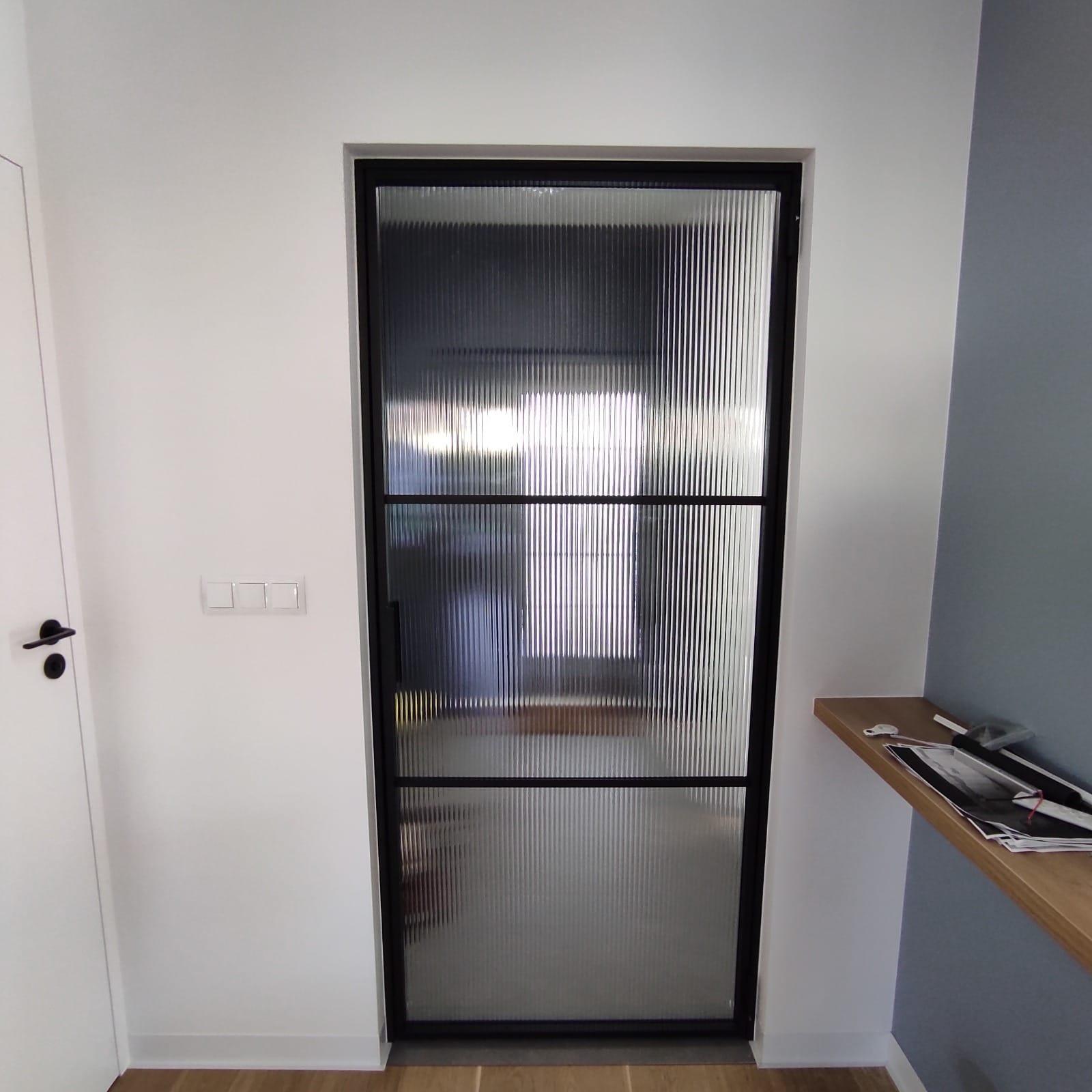 Internal door in reeded glass and a slim black steel frame