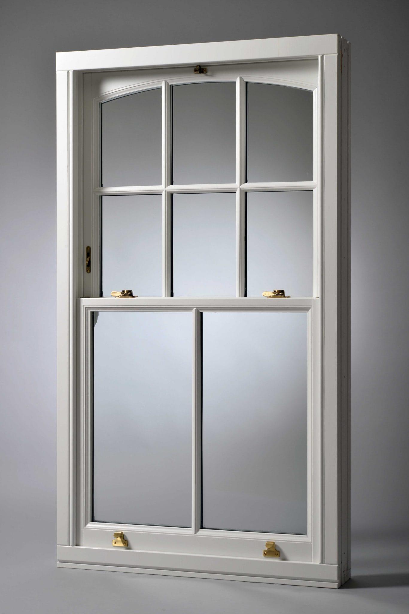Timber box sash window with an arched head and brass fittings, shown out of the opening