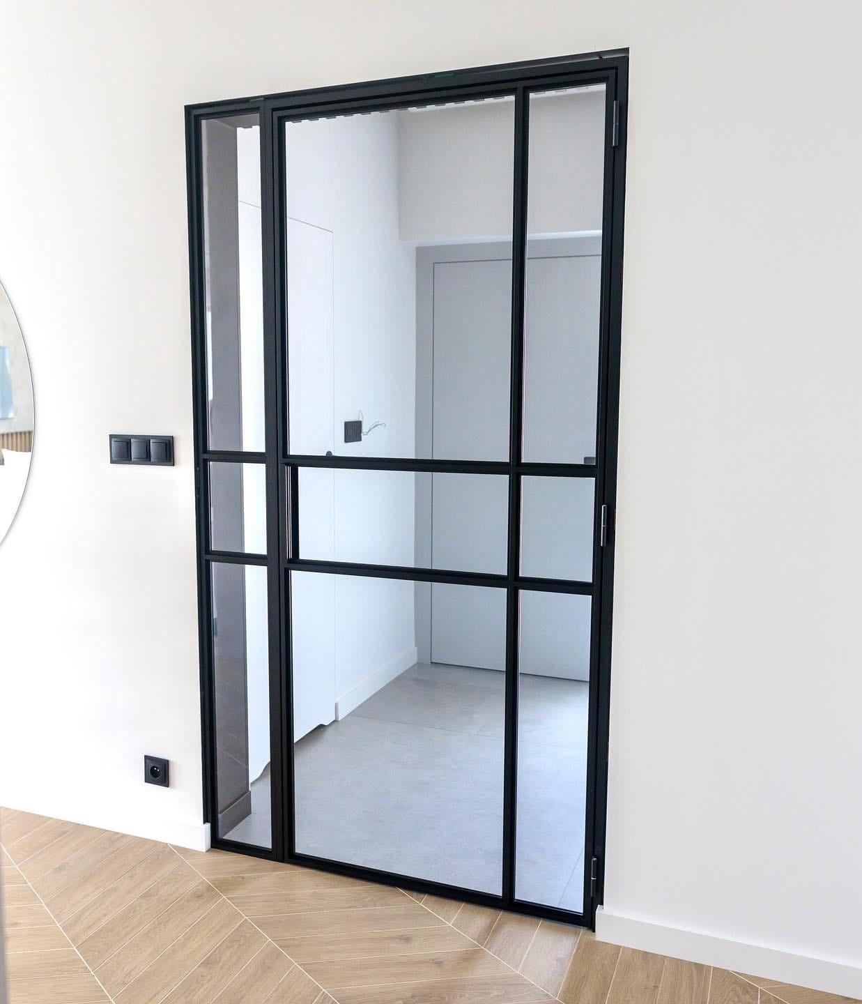 Black steel-framed glazed door opening into a small utility room