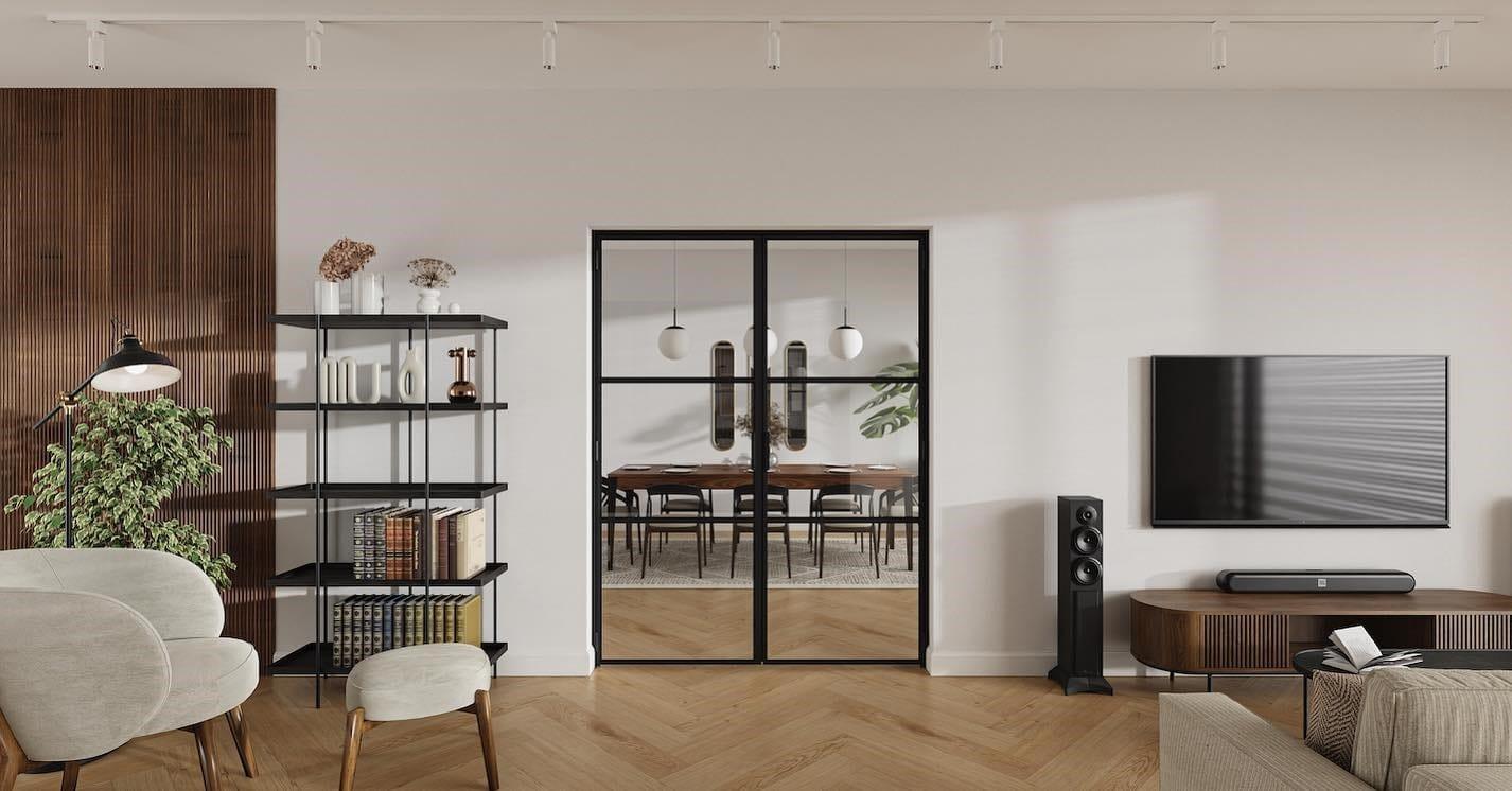 Living room with a black steel glazed screen through to the dining room, over herringbone flooring