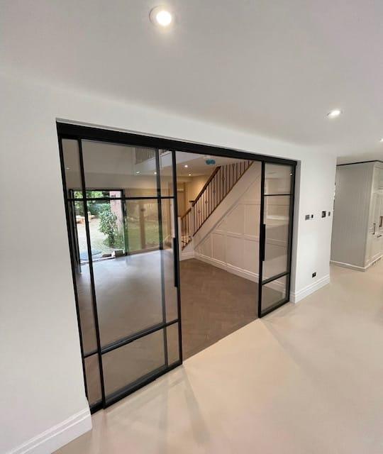 Black steel sliding screen drawn back beside a staircase