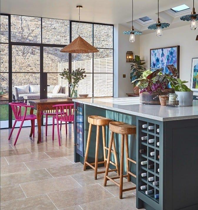Kitchen with Crittall-style glazing onto a garden room, a teal island and a rooflight over