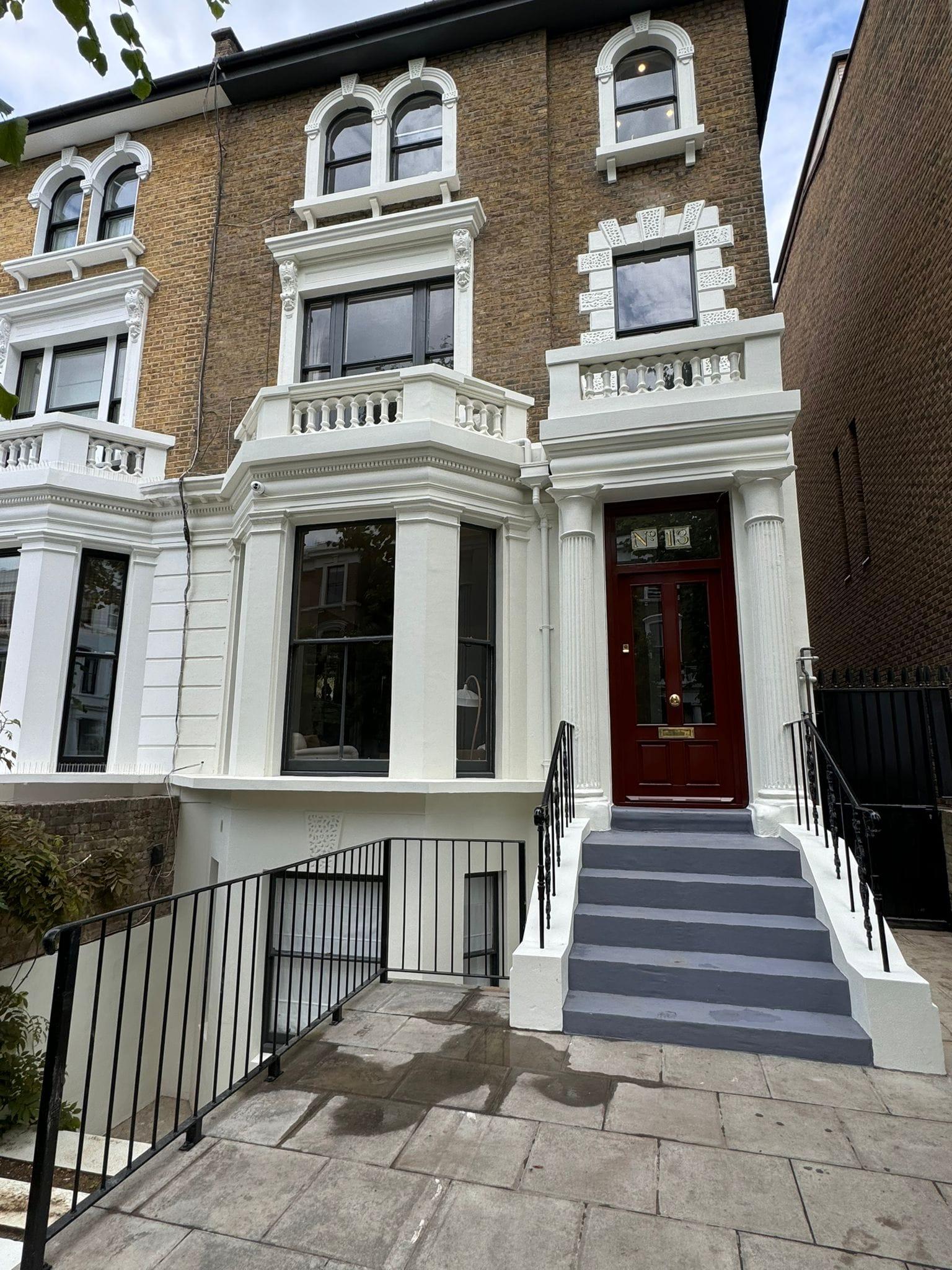 Stuccoed Victorian villa elevation with a red front door and restored render and mouldings