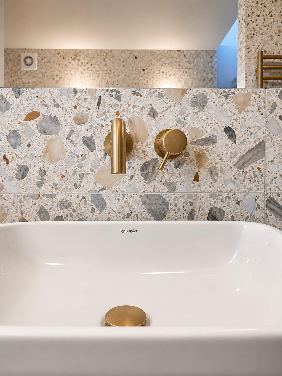 Brass bath filler against terrazzo tiling, close detail — Moncrieff Street, Peckham SE15