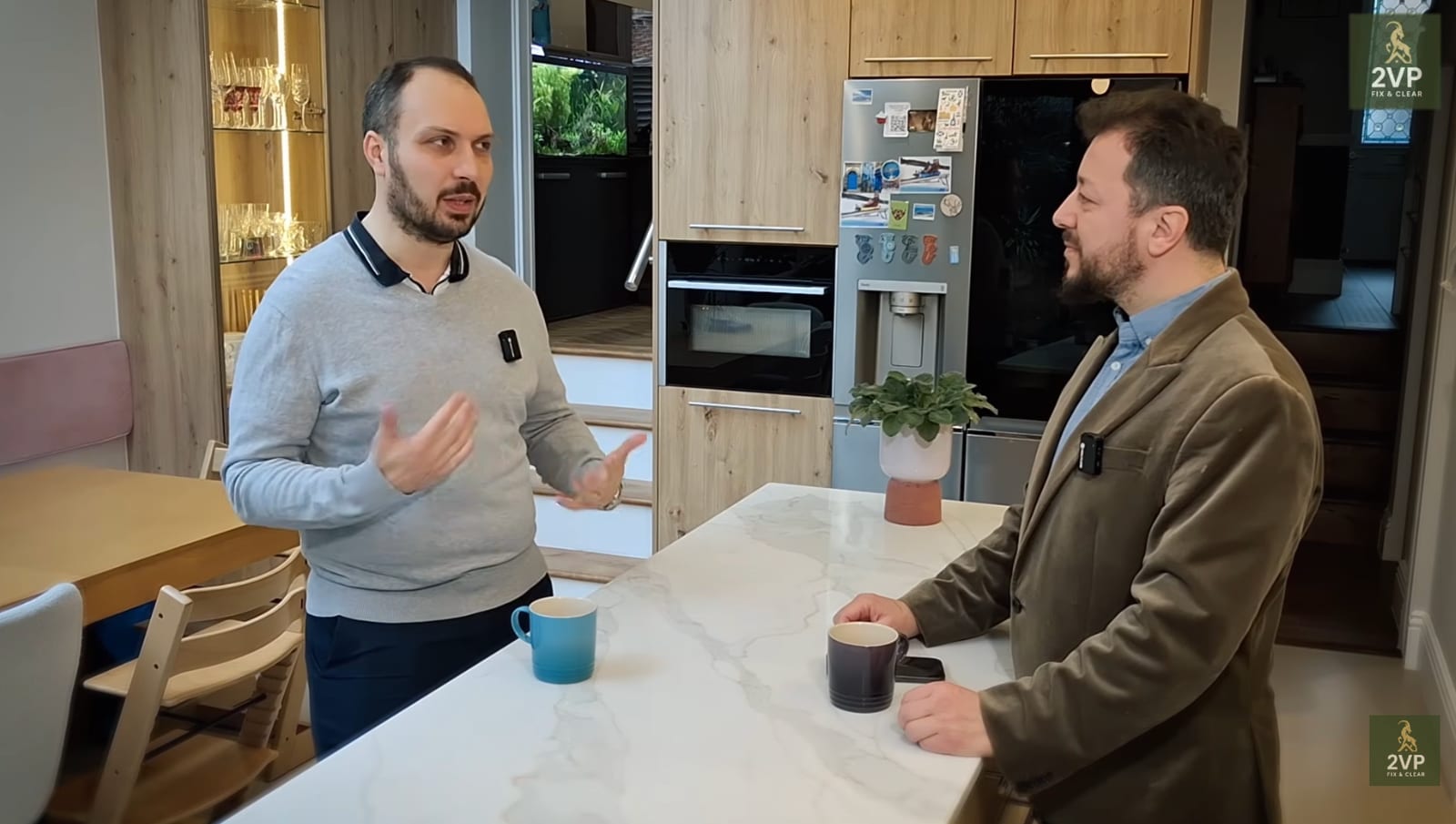 Konrad, the homeowner, talking with Vladimir Castravet across the island of his finished kitchen — a still from the film about the job that overran