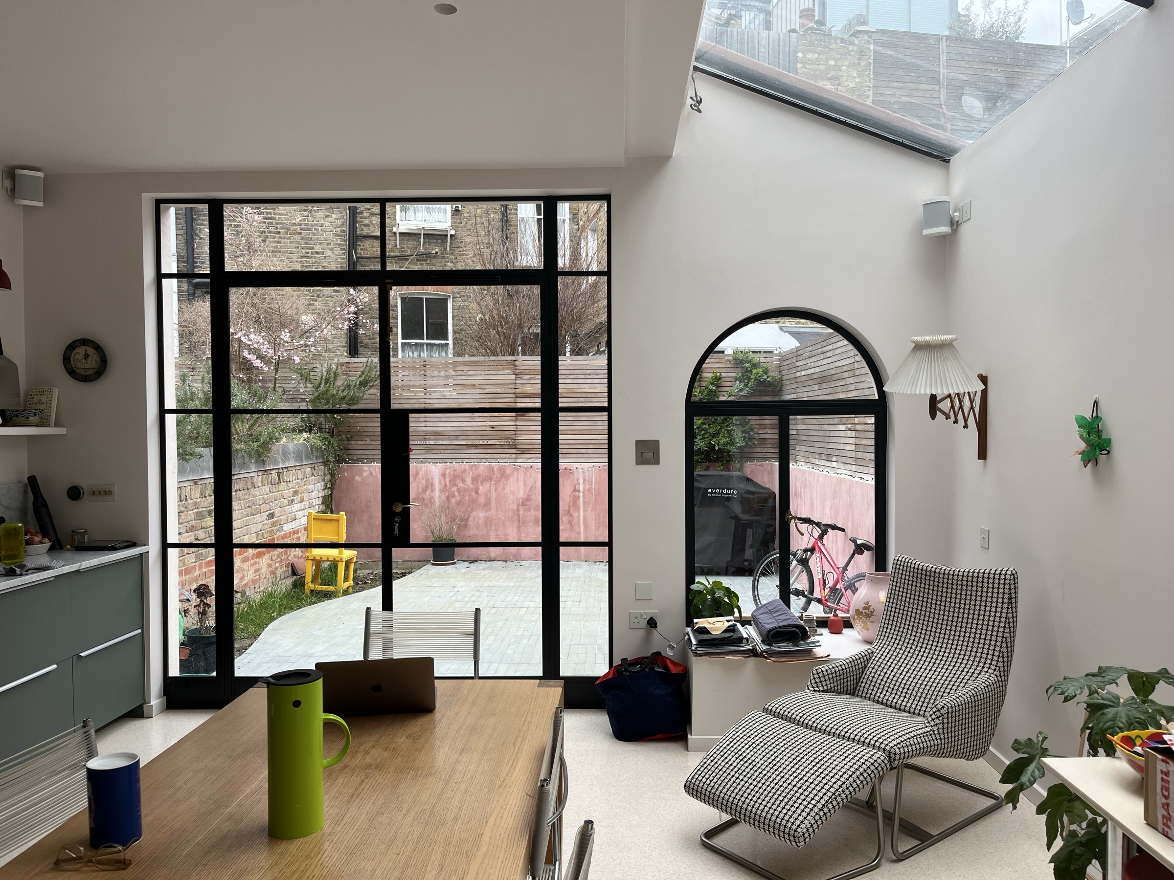 Rear extension interior with a full-height Crittall screen to the garden, arched window and a long rooflight